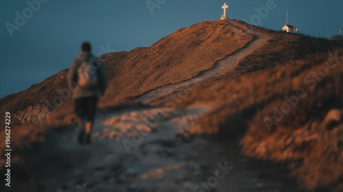 Dramatic wide shot of a lone pilgrim walking a winding mountain path toward a hilltop cross in golden afternoon light