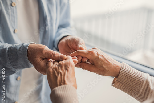 Obraz na plátne An elderly couple gently holding hands in a close-up moment of tenderness and su