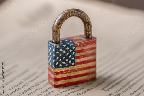 Worn padlock painted with the American flag resting on papers, symbolizing USA privacy, document security, legal compliance, and protected information.
