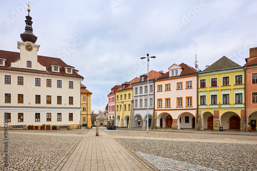 Historic town square with colorful buildings under cloudy sky