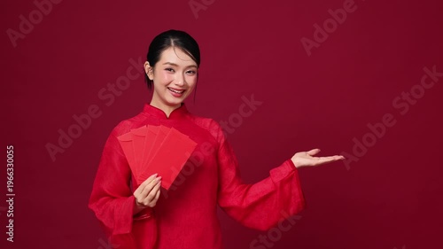 Asian woman introducing with one hand gesture, red holiday outfit, friendly and inviting mood for seasonal design