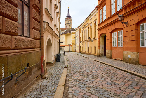 Принти на полотні Charming european cobblestone street with historical buildings and tower view