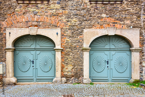 Rustic brick architecture with vintage wooden double doors and stone archways