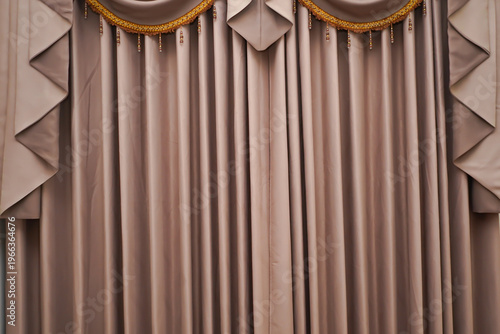 Foto Elegant beige luxury curtain with layered swags and gold trim tassels, classic interior drapery design creating a sophisticated and formal decorative backdrop