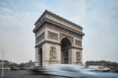 Arc de Triomphe monument in Paris with blurred traffic and classic urban architecture