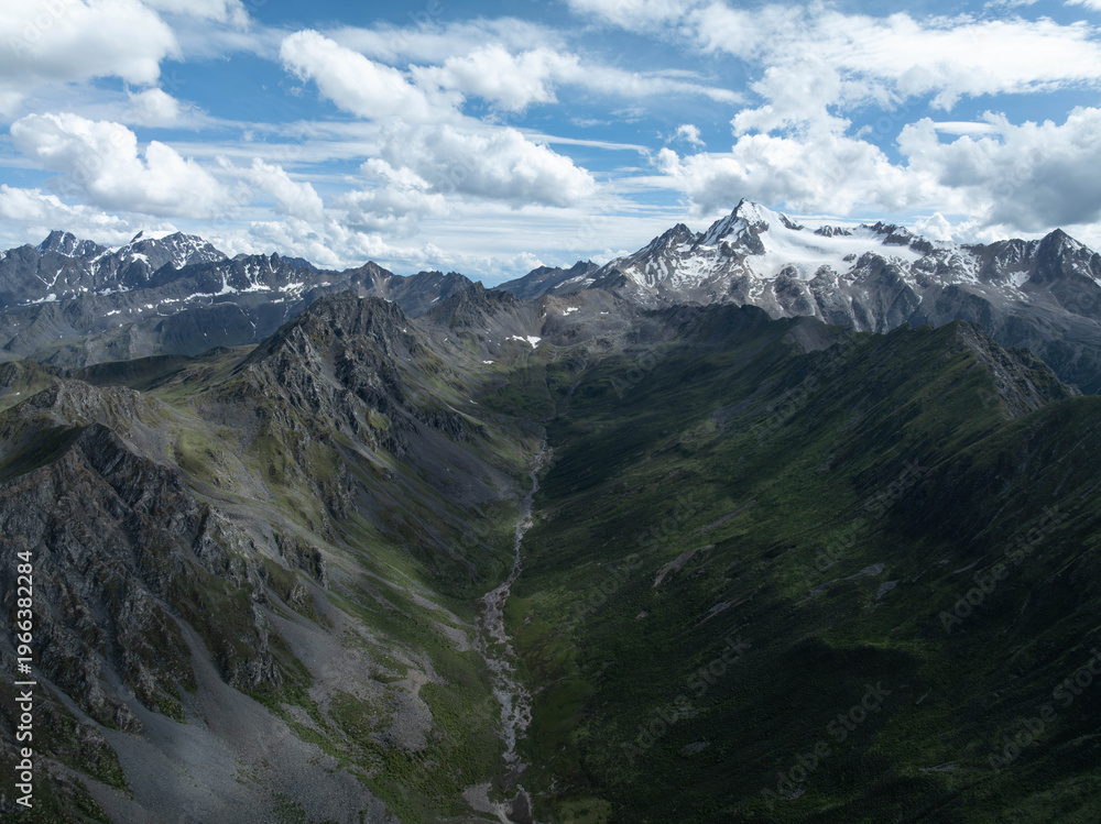Obraz premium Aerial view of beautiful high altitude snow capped mountain and forest landscape