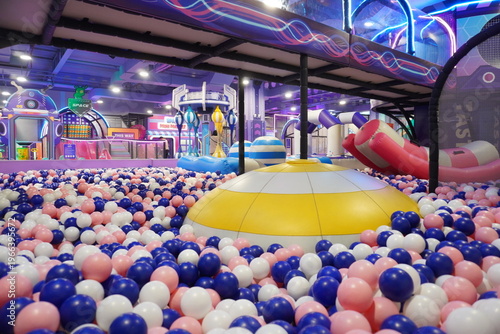 Indoor playground with colorful ball pit and spacethemed decorations