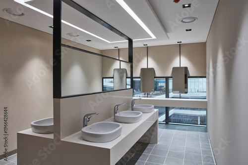 Clean modern restroom vanity with double sinks and mirrors in contemporary commercial interior