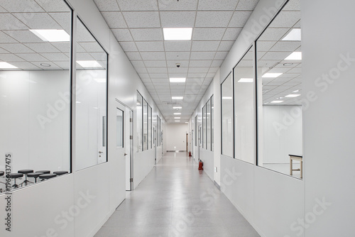 Long white corridor with open office overlook in modern institutional building