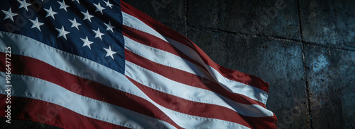 American flag with stars and stripes, fluttering against a textured, dark background. Symbolizes patriotism, national identity, and American heritage.