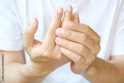 Photos Man holding his hand suffering from finger joint pain or numbness; concept of ar