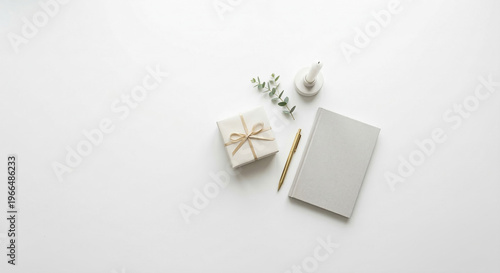 Minimalist flatlay with wrapped gift grey notebook and candle on white