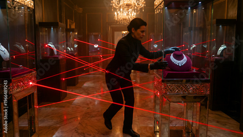 A stealthy, black-clad female operative carefully navigates a complex network of bright red laser security beams while attempting to expertly retrieve a luxurious, valuable diamond necklace from an
