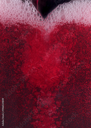 Close-up of red wine bubles in a transparent glass on black backgrond