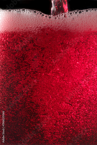 Close-up of red wine bubles in a transparent glass on black backgrond
