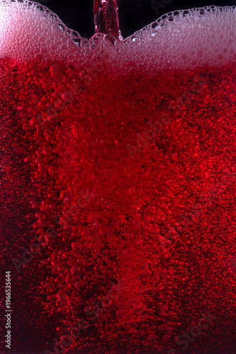 Close-up of red wine bubles in a transparent glass on black backgrond