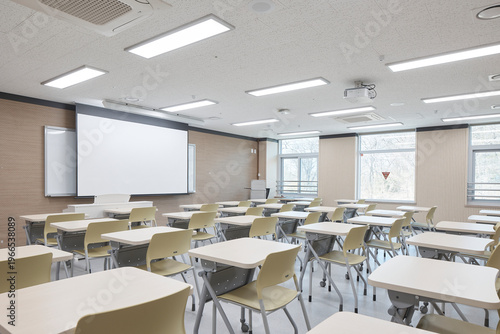 Modern classroom with yellow chairs and projection screen in academic interior