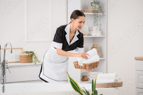 Young chambermaid with bask...