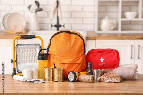 Orange emergency backpack with necessities on table in kitchen