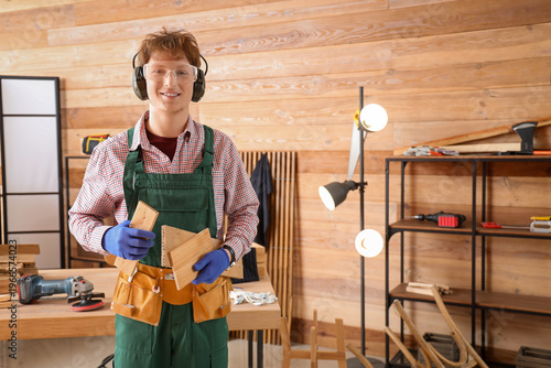Young carpenter with wooden...