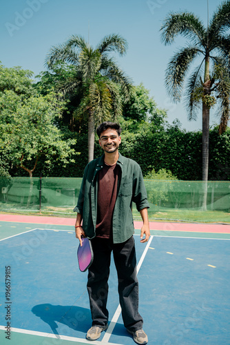 Indian Man playing pickleball on an outdoor court, showcasing an active lifestyle, sports activity, and recreational fitness. Concept of modern sports, healthy living, and outdoor games.