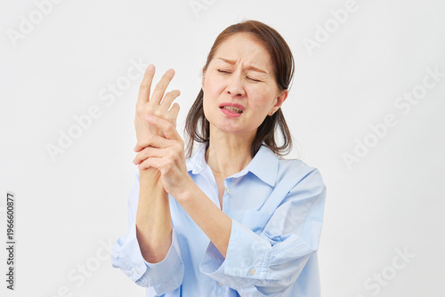 白背景で手の痛みに悩む女性