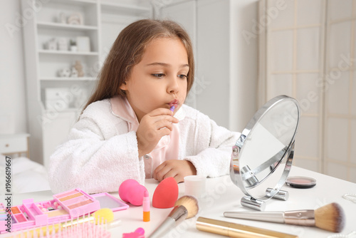 Cute little girl using cosm...