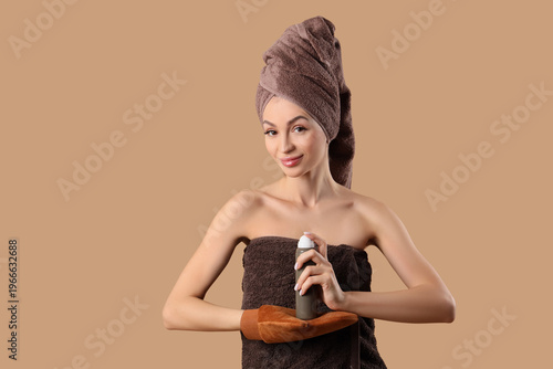 Принти на полотні Young woman in towel with massage glove and bottle of self tanner mousse on beig