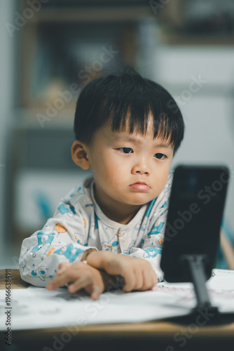 Toddler Watching Smartphone While Drawing at Table