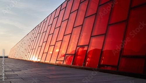 Obraz na płótnie Modern architecture with red glass facade and reflection at sunset 夕暮れ時の反射が美しい赤いガラス張りのファサードを持つ近代建築