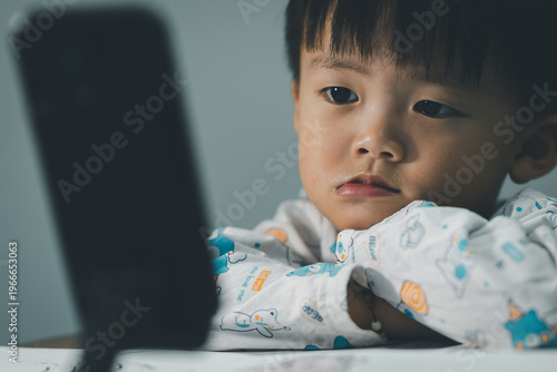 Toddler Watching Smartphone While Drawing at Table