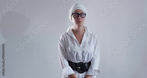Business goal-oriented young woman in glasses and turban thought. Front view