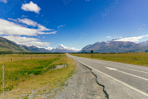 Empty Highway Toward Distant Snowy Mountain Range