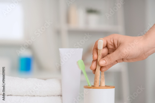 Female hand with toothpaste...