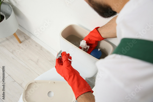 Male plumber repairing toil...