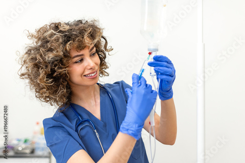 Photos Smiling nurse administering medicine through IV drip