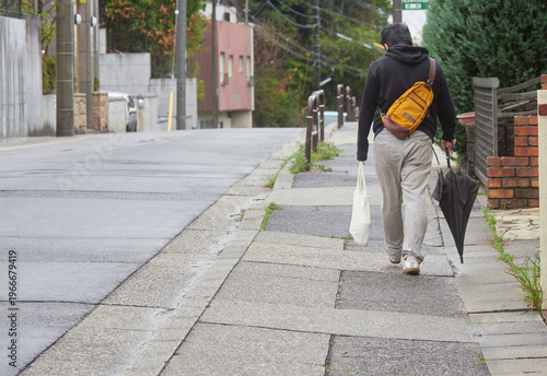 春の住宅街で歩く一人の男性の姿