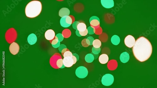 A vibrant and festive abstract background featuring a bokeh effect with out-of-focus circular lights in red, green and gold hues against a solid