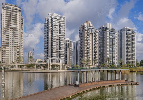 Landscape of ecological lake and residential buildings in Petah Tikva Park.