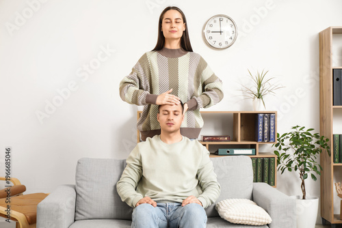 Female psychologist hypnotizing man in office