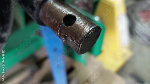 Applying Brown Lubricating Grease to a Metal Pin with a Brush