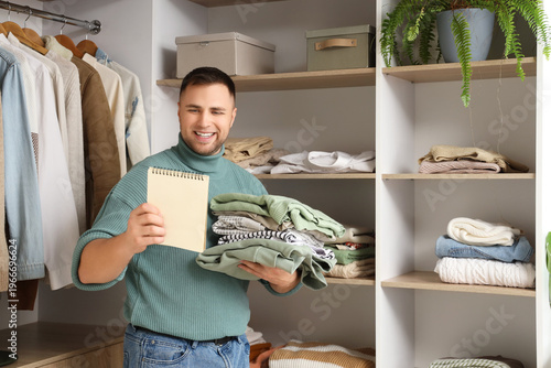 Young man with stack of clo...