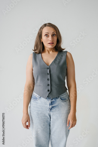 Surprised Young Woman Posing in Grey Vest and Jeans