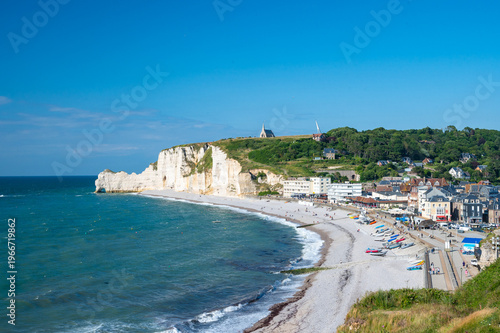 Aerial view of Etretat beach cliffs and hilltop chapel with fishing boats Normandy