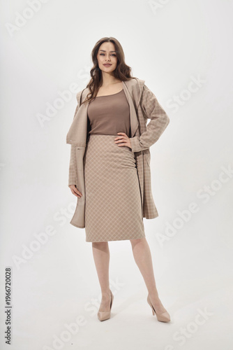 Elegant Fashion Display Featuring a Model in Stylish Layered Attire with Neutral Tones and Classic Silhouette