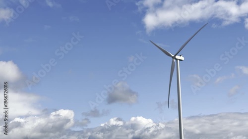 Mid distance view of a wind turbine turning against a blue sky with light clouds in rural Vendée France, highlighting renewable energy generation within an agricultural setting