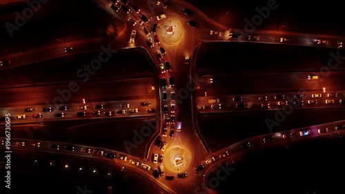 Aerial top view of night road with round about filmed from above at night time in Tbilisi. Evening overpass in Georgia showing stalled trucks and cars across multiple lanes and queued vehicles 