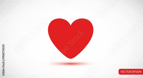A large red heart is sitting on a white surface with a subtle shadow underneath.