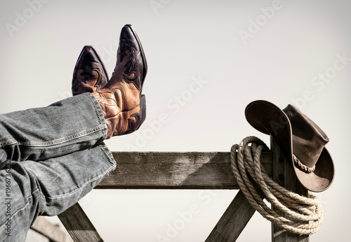 Cowboy boots and hat with feet up resting with legs crossed