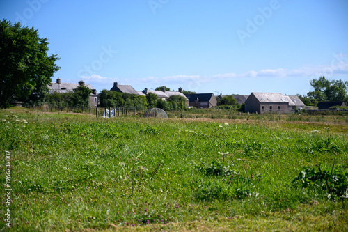 Принти на полотні Rural Normandy village houses seen across a green meadow France